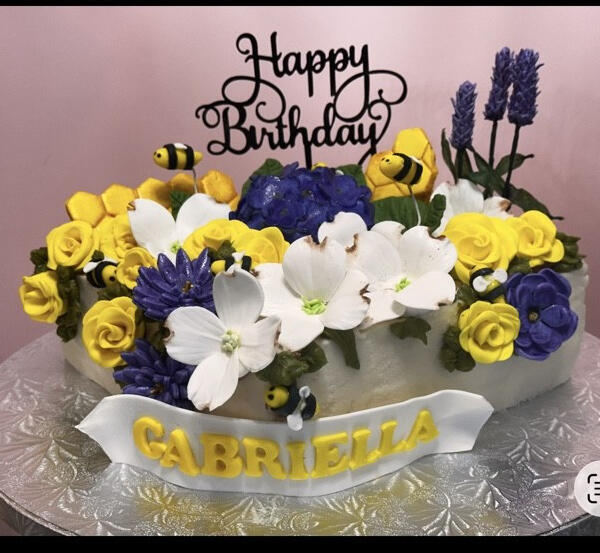 Floral Bee Birthday Cake Custom birthday cake featuring handcrafted sugar flowers, bees, lavender, and personalized fondant details.